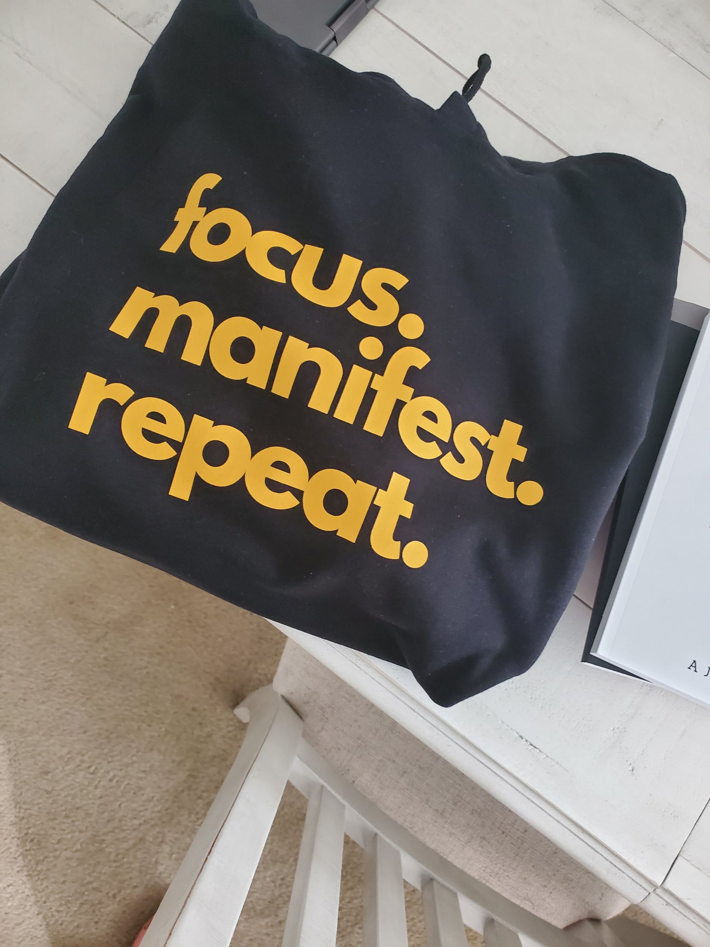 Black hoodie gold letters focus manifest repeat